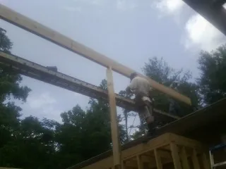 Carpenter setting a ridge beam over a new addition frame — Ice Dam Removal by Roofing Brothers in Rocky Hill