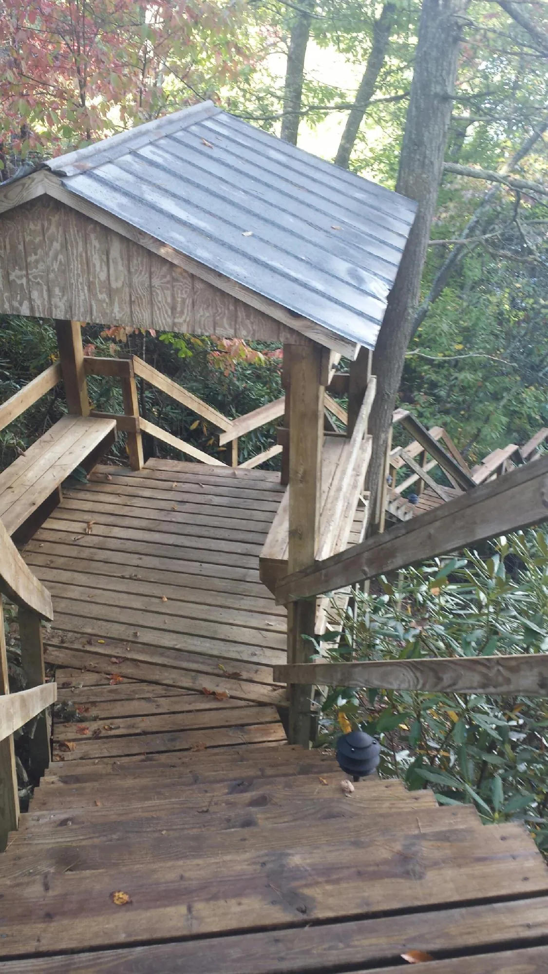 Metal roofed shelter over wooden steps on a wooded walkway — Skylight Repair & Installation work by our crew in Rocky Hill